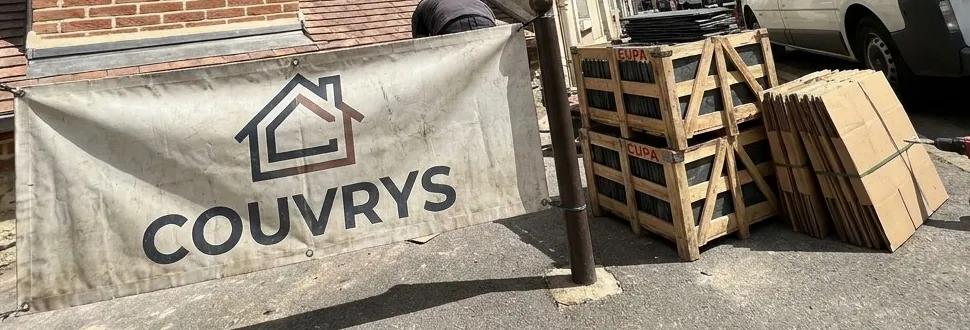 Bâche Couvrys sur un chantier de Mantes-la-Jolie, palettes d'ardoises rangées contre le trottoir