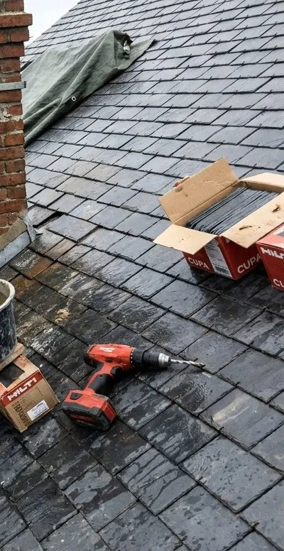 Toiture en ardoise en cours de réfection à Mantes-la-Jolie, caisses d'ardoises neuves et outillage du couvreur
